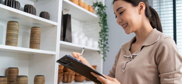 Asian beautiful woman check vase goods order for customer from shelf. Young attractive business girl working to preparing parcel boxes checking ecommerce shipping online retail to sell at home store.