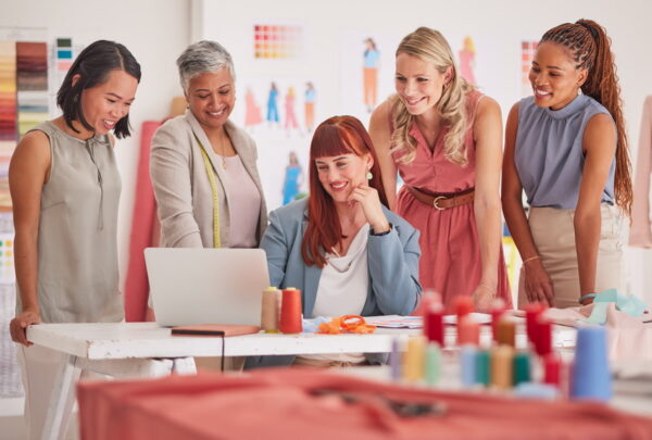 Business people, laptop and fashion meeting for marketing, clothing or ecommerce at the office. Gro.